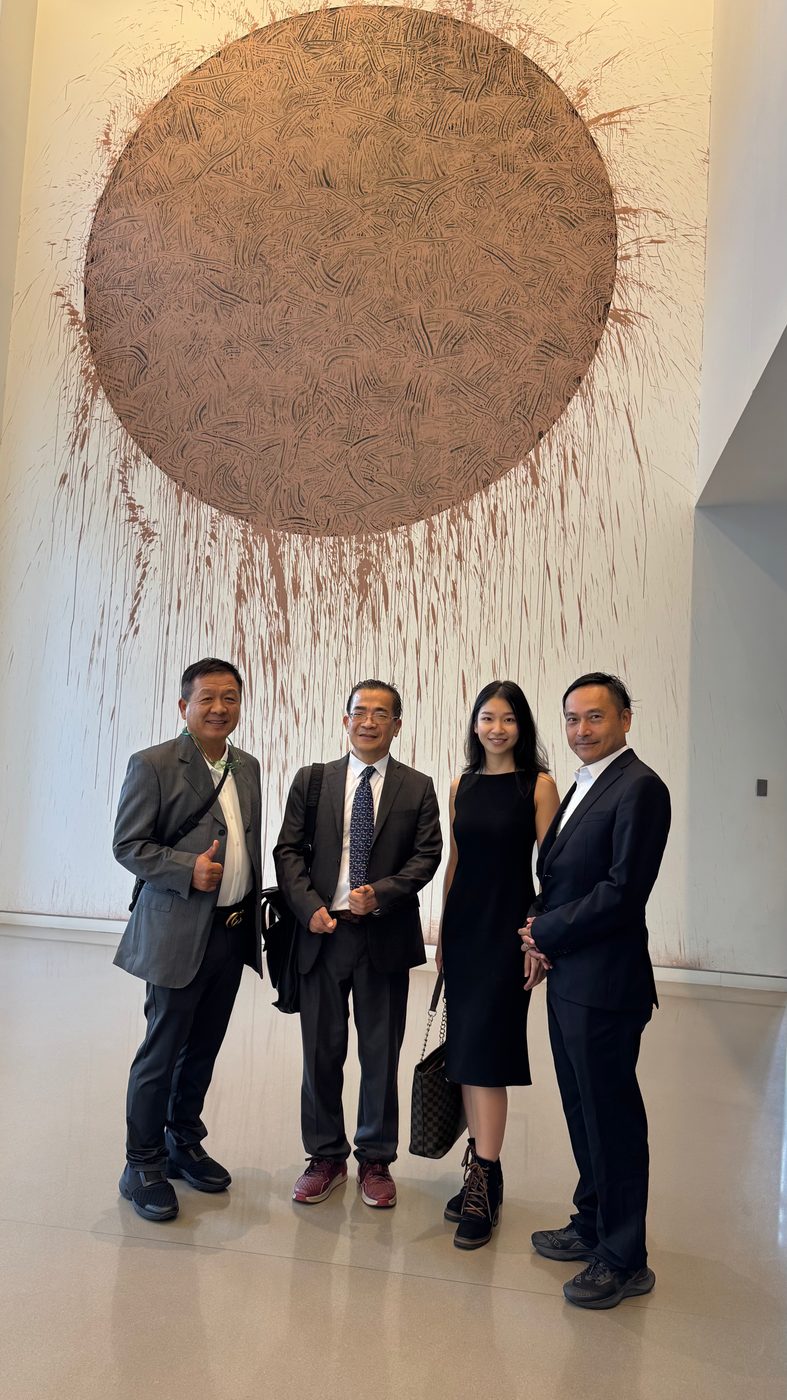 沈成与一群商务嘉宾在画廊合影