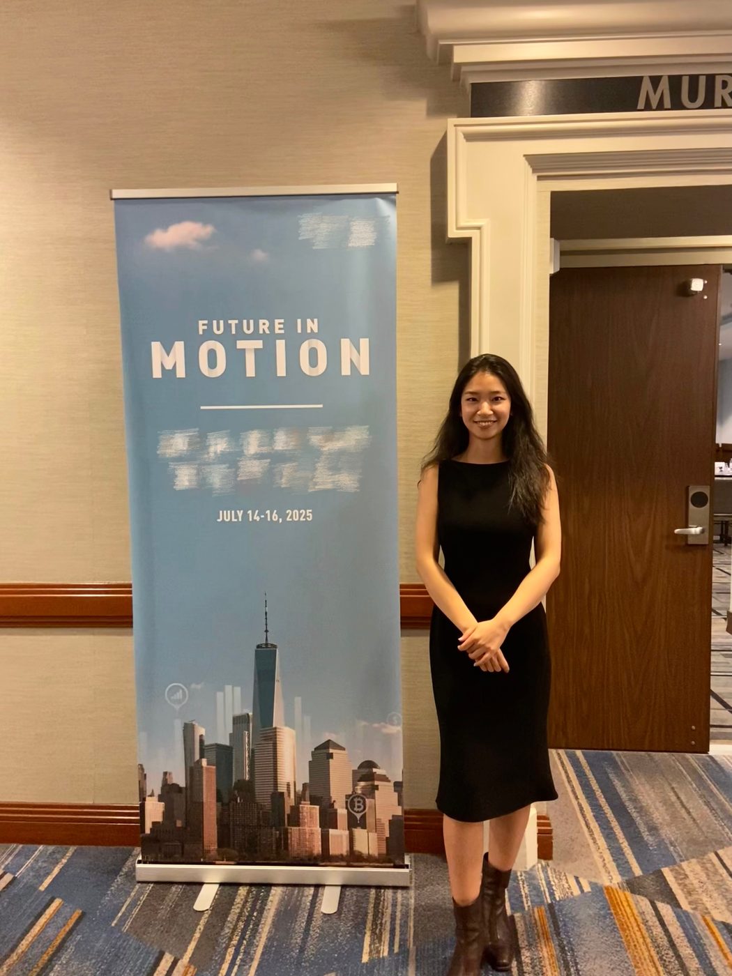 沈成站在 Future in Motion 会议的背景板旁